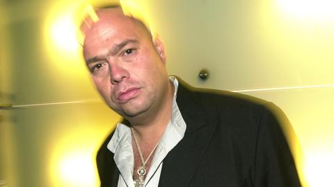 Mark Spoon blickt ernst in die Kamera und ist von strahlenden Lichtern umgeben