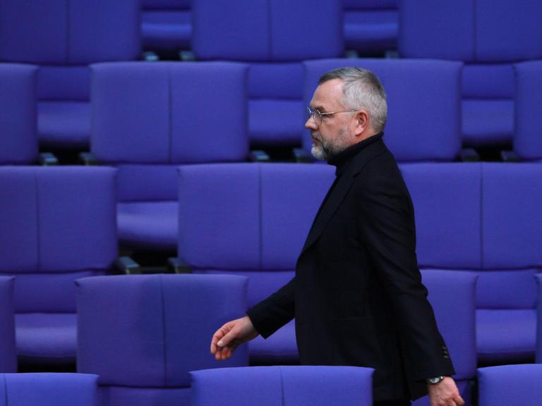 Der SPD-Außenpolitiker Michael Roth läuft durch leere Stuhlreihen im Bundestag. 