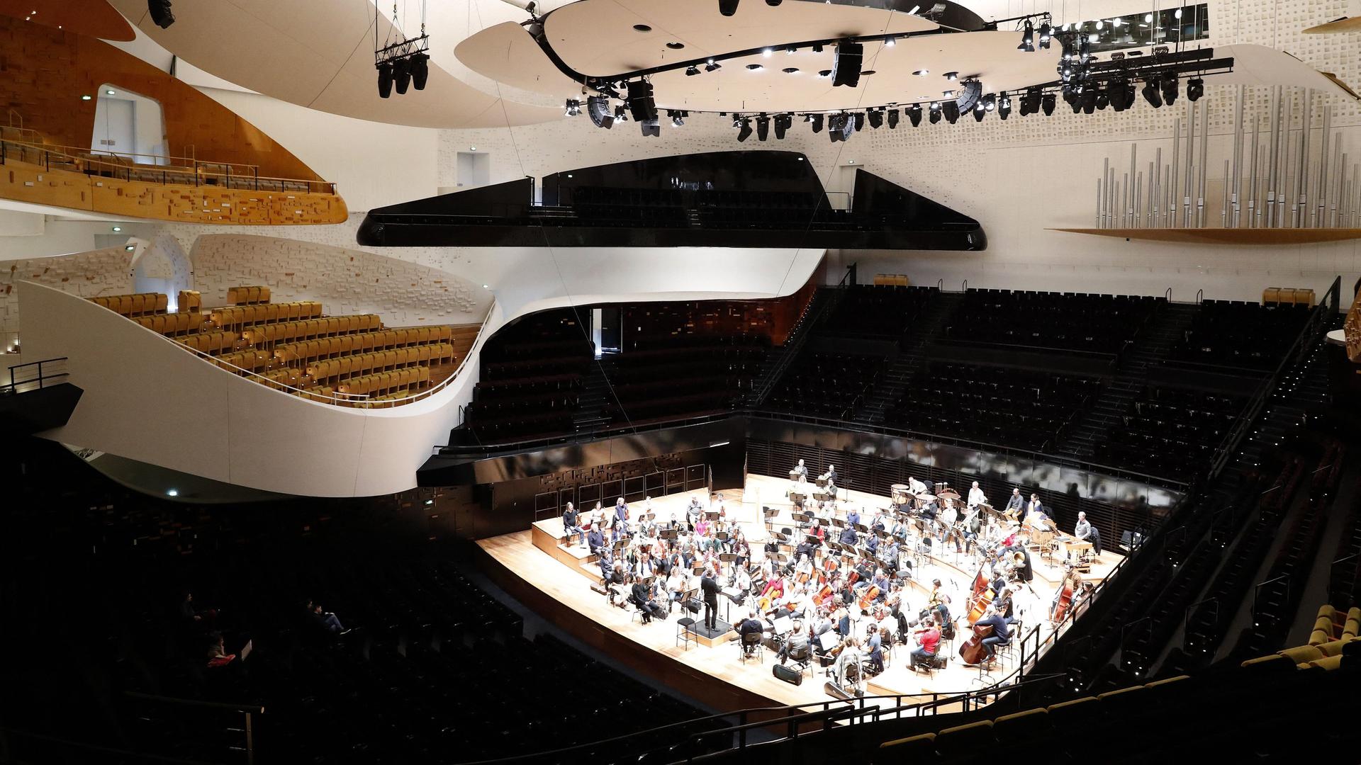 Ein Blick von oben in die Philharmonie de Paris mit Sitzreihen und dem Platz fürs Orchester in der Mitte.