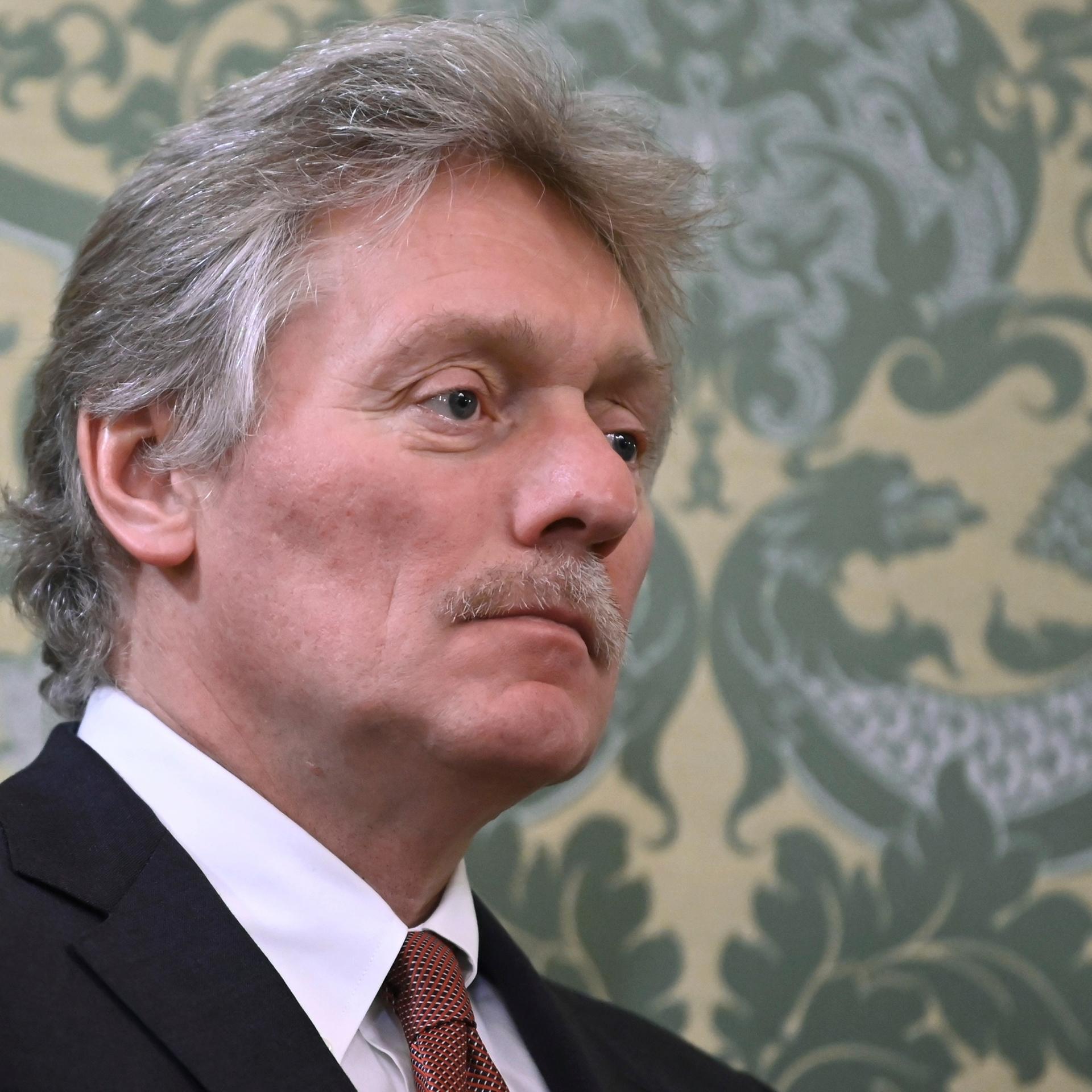 Das Foto zeigt Dmitri Peskow. Er blickt ernst.