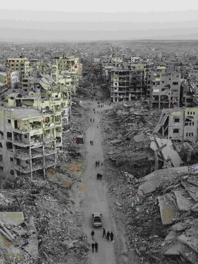 Luftbild der Zerstörung im Viertel Sheikh Ridwan in Gaza Stadt: Zerbombte Häuser, einige sind nur noch Schutt und Asche. Auf einer Straße laufen Menschen, die nach dem Waffenstillstandsabkommen unter schwierigsten Bedingungen überleben.