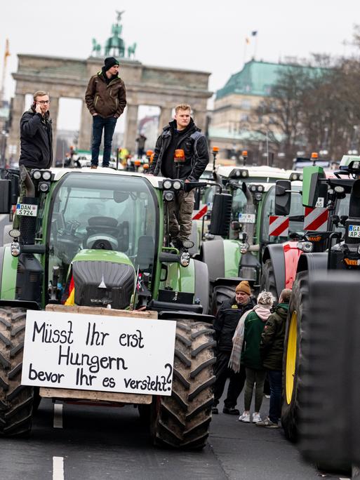 Landwirte nehmen mit Traktoren mit der Aufschrift „Müsst ihr erst Hungern bevor ihr es versteht“ auf einer Demonstration des Deutschen Bauernverbandesvor dem Brandenburger Tor teil. Landwirte nehmen mit Traktoren mit der Aufschrift „Müsst ihr erst Hungern bevor ihr es versteht“ auf einer Demonstration des Deutschen Bauernverbandesvor dem Brandenburger Tor teil.