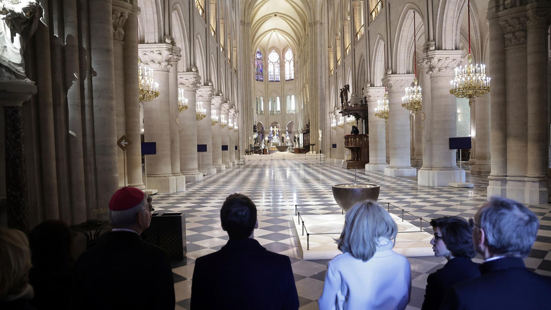 Mehrere Personen stehen im Vordergrund, mit dem Rücken zur Kamera. Sie schauen in ein prächtiges Kirchenschiff. 