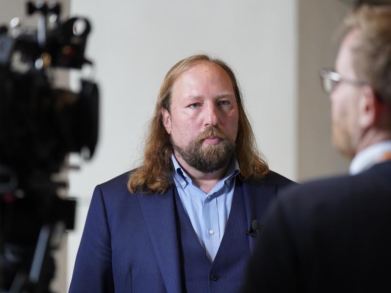 Anton Hofreiter steht bei einem Pressestatement am Rande einer Bundestagssitzung vor einer Kamera.