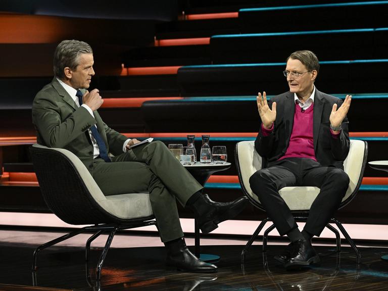 Karl Lauterbach (r.) sitzt dem Moderator Markus Lanz (l.) im Fernsehstudio gegenüber und spricht.