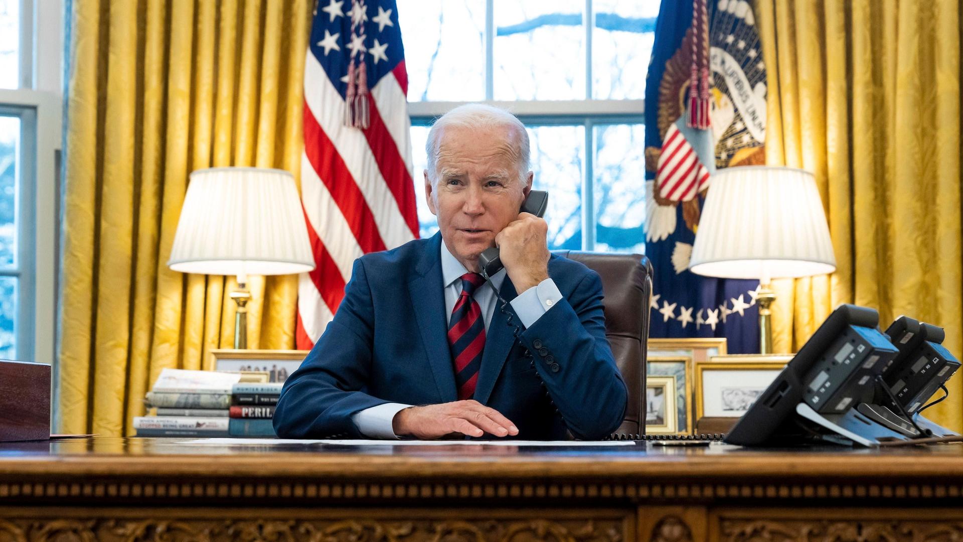 US-Präsident Biden sitzt in seinem Büro in Washington und telefoniert. 