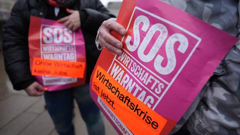 Teilnehmende halten Plakate «SOS - Wirtschaftskrise ist jetzt» anlässlich des Wirtschaftswarntags in der Hand - eine Initiative von über 90 Verbänden mit der Interessenvertretung Die Familienunternehmer e.V. 