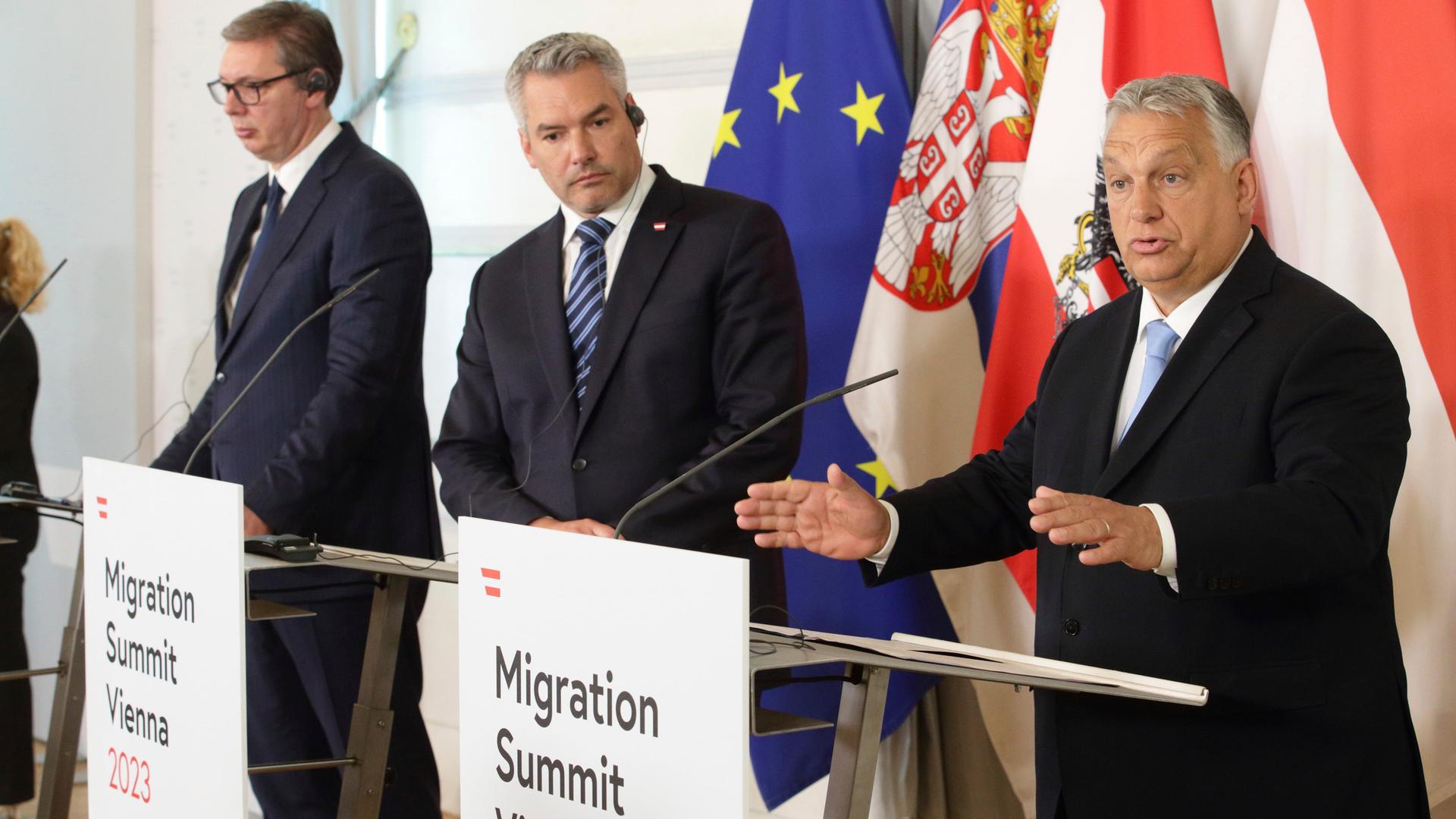 Aleksandar Vucic, Präsident von Serbien, Karl Nehammer, Bundeskanzler von Österreich, und Viktor Orban, Ministerpräsident von Ungarn, stehen nebeneinander an Rednerpulten.