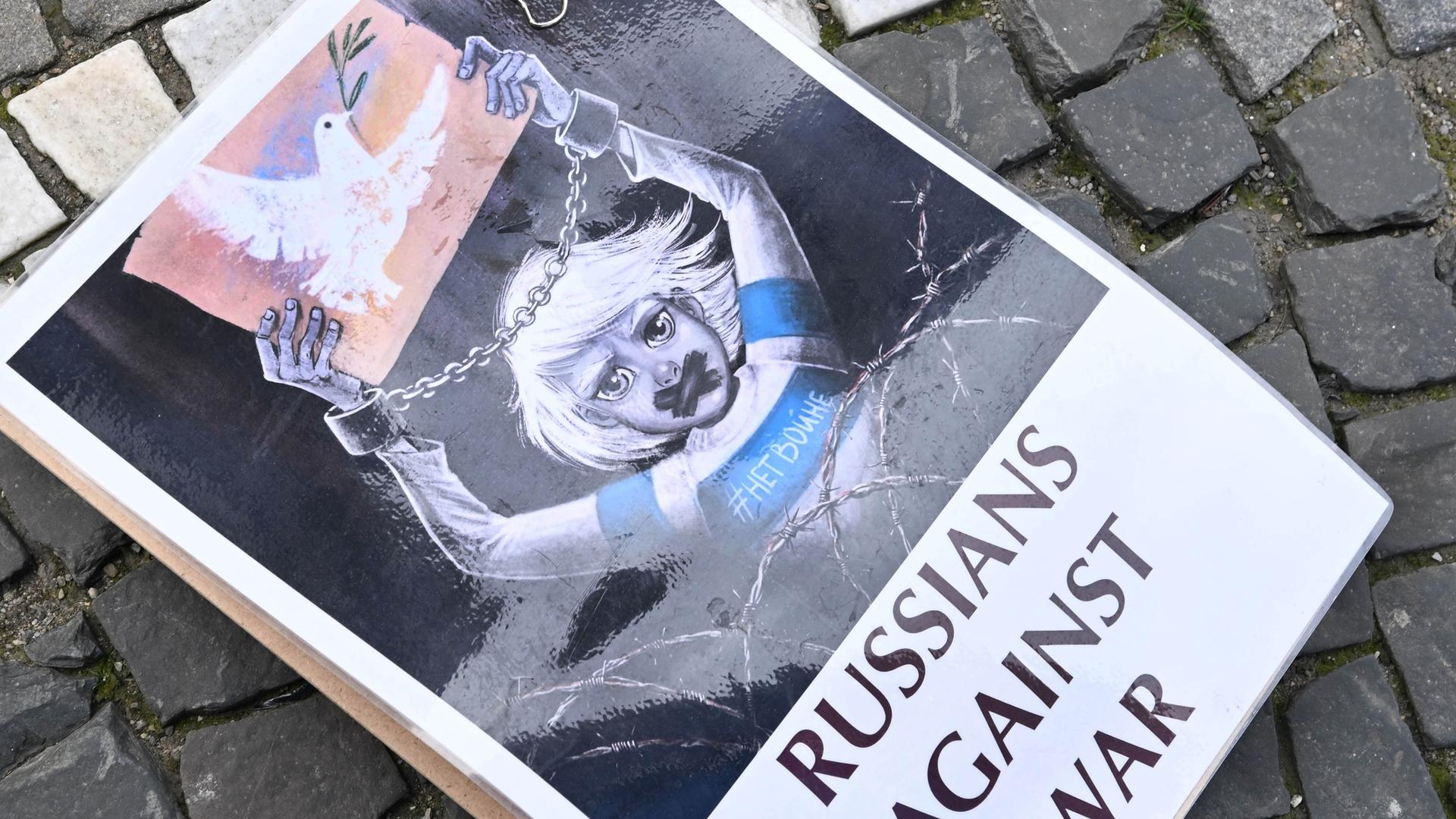 Ein Schild mit der Aufschrift "Russians against war" liegt bei einer Demonstration des Vereins Free Russians auf dem Boden. 