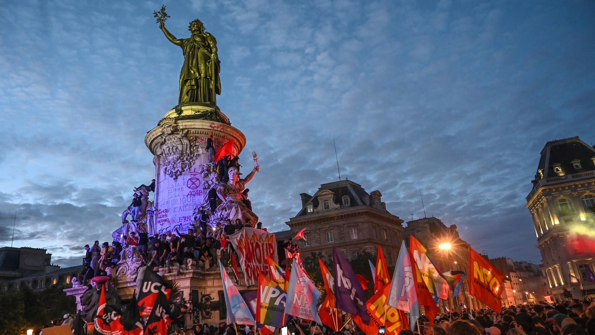 Auf dem Platz der Republik feiern zahlreiche Menschen und schwenken farbenfrohe Fahnen.