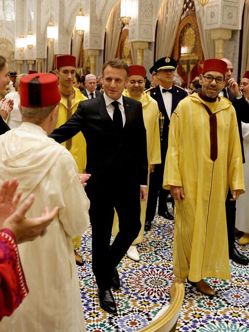 Frankreichs Präsident Emmanuel Macron und Marokkos König Mohammed VI gehen gemeinsam durch die Reihen einer Dinner-Gesellschaft im königlichen Palast in Rabat. 
