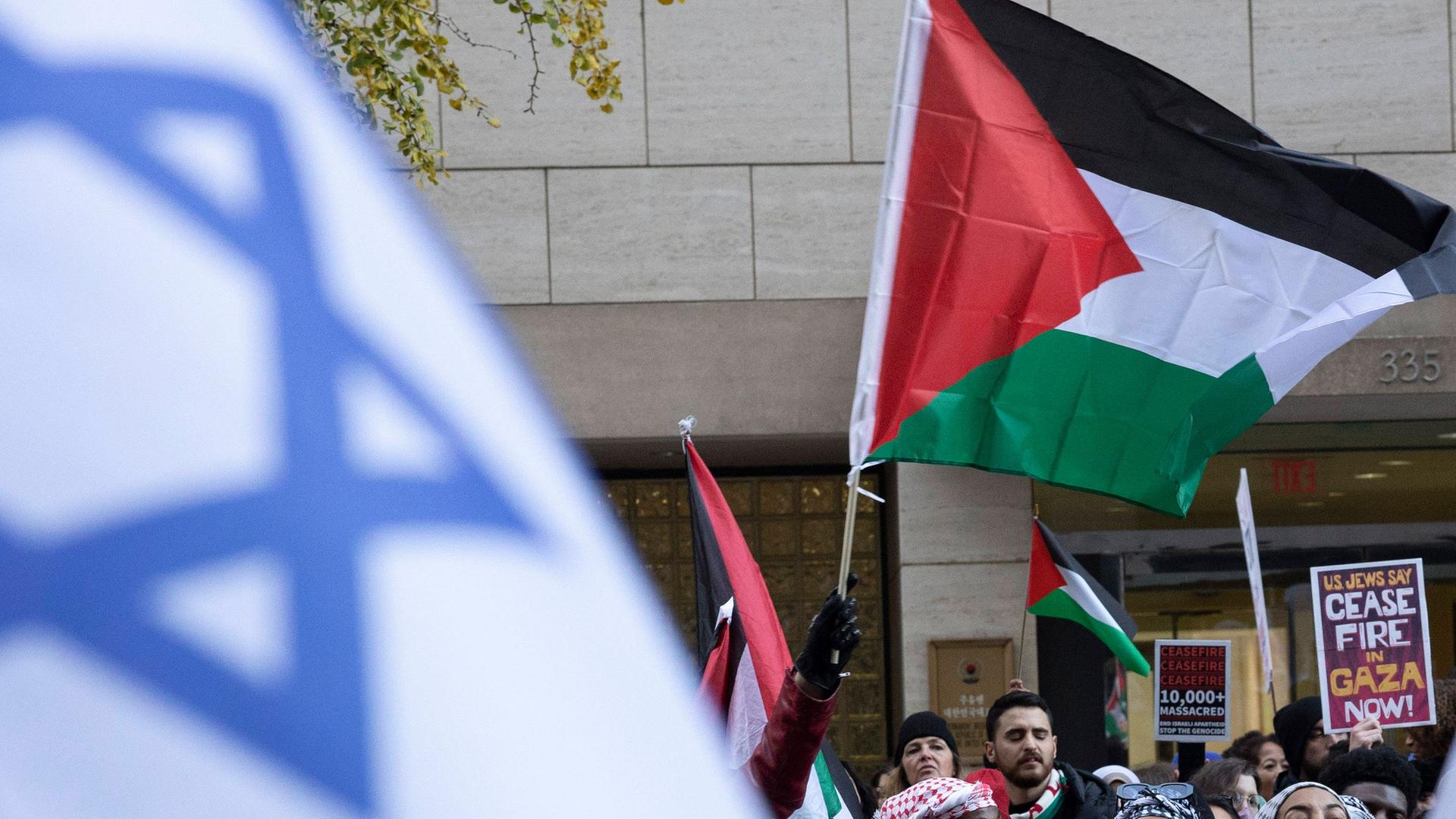 Dicht gedrängte Menschengruppen mit palästinensischen und israelischen Flaggen