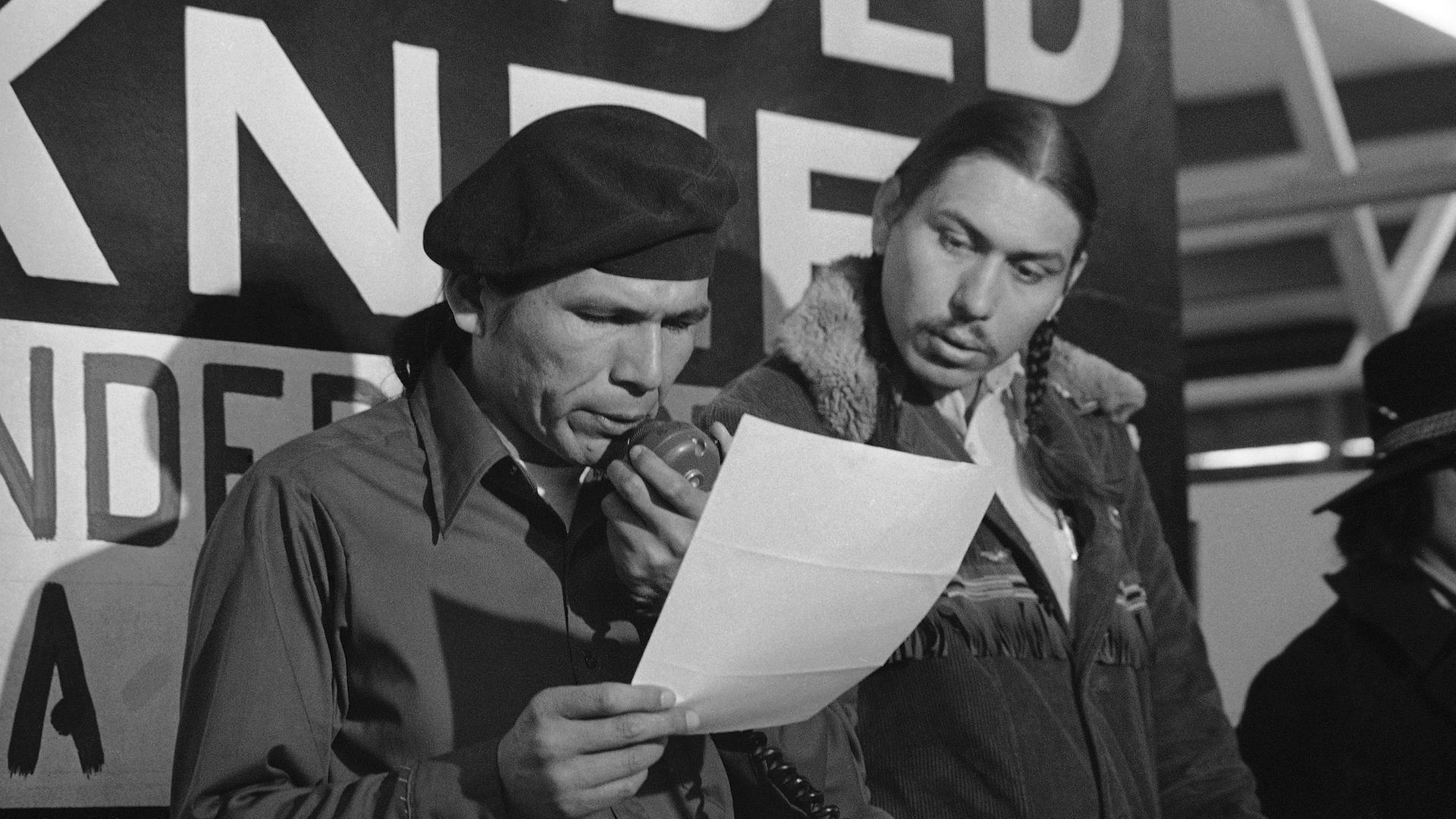 Im Frühjahr 1973 verlas einer der Aktivisten der protestierenden Native Americans in  Wounded Knee, South Dakota, Dennis Banks, eines der Angebote der US-Regierung in Reaktion auf die Besetzung der Reservation. (AP Photo/Jim Mone, File)