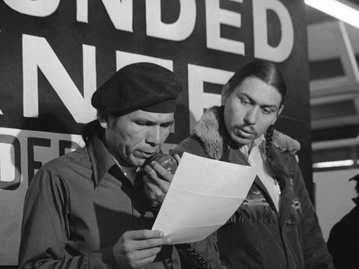 Im Frühjahr 1973 verlas einer der Aktivisten der protestierenden Native Americans in  Wounded Knee, South Dakota, Dennis Banks, eines der Angebote der US-Regierung in Reaktion auf die Besetzung der Reservation. (AP Photo/Jim Mone, File)