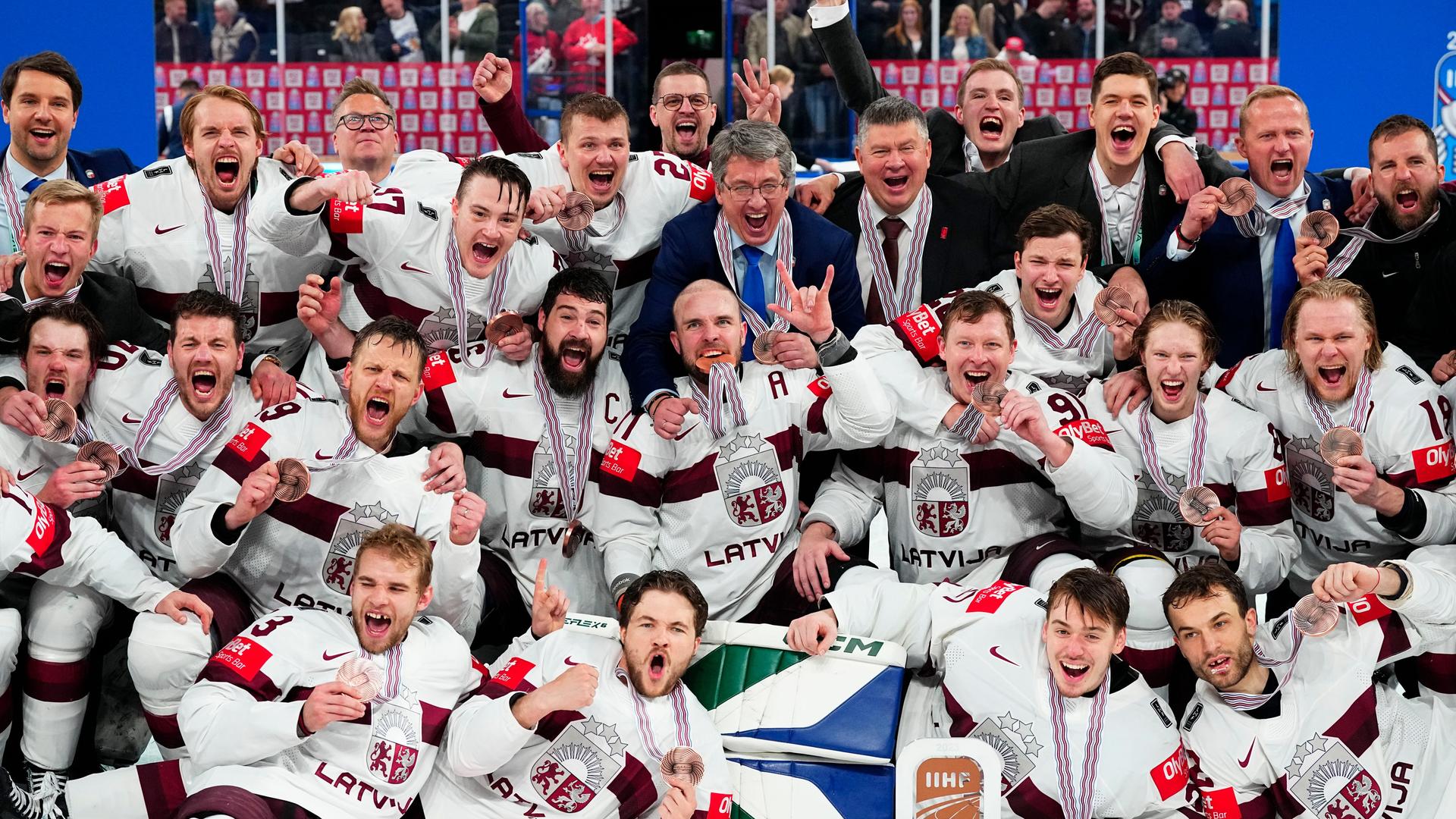 Das Foto zeigt die Spieler der lettischen Eishockey-Nationalmannschaft. Sie posieren nach der Siegerehrung zusammen für Fotos.