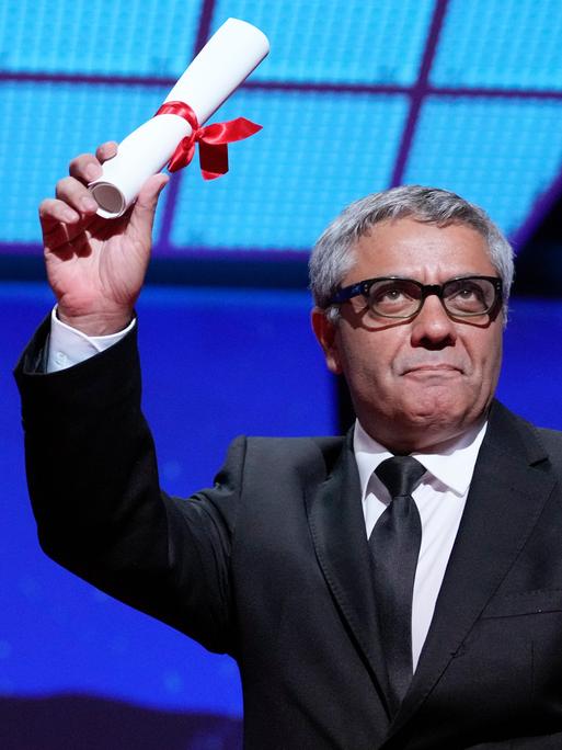 Auf dem Filmfestival in Cannes hält der iranische Filmemacher Mohammad Rasoulof eine Papierrolle in die Höhe - der Spezialpreis für seinen Film "The seed of the sacred fig". 