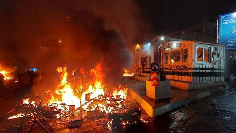 Hell loderndes Feuer vor einem weißen Gebäude. 