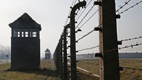 Wachtürme und ein Stacheldrahtzaun am Vernichtungslager Auschwitz.