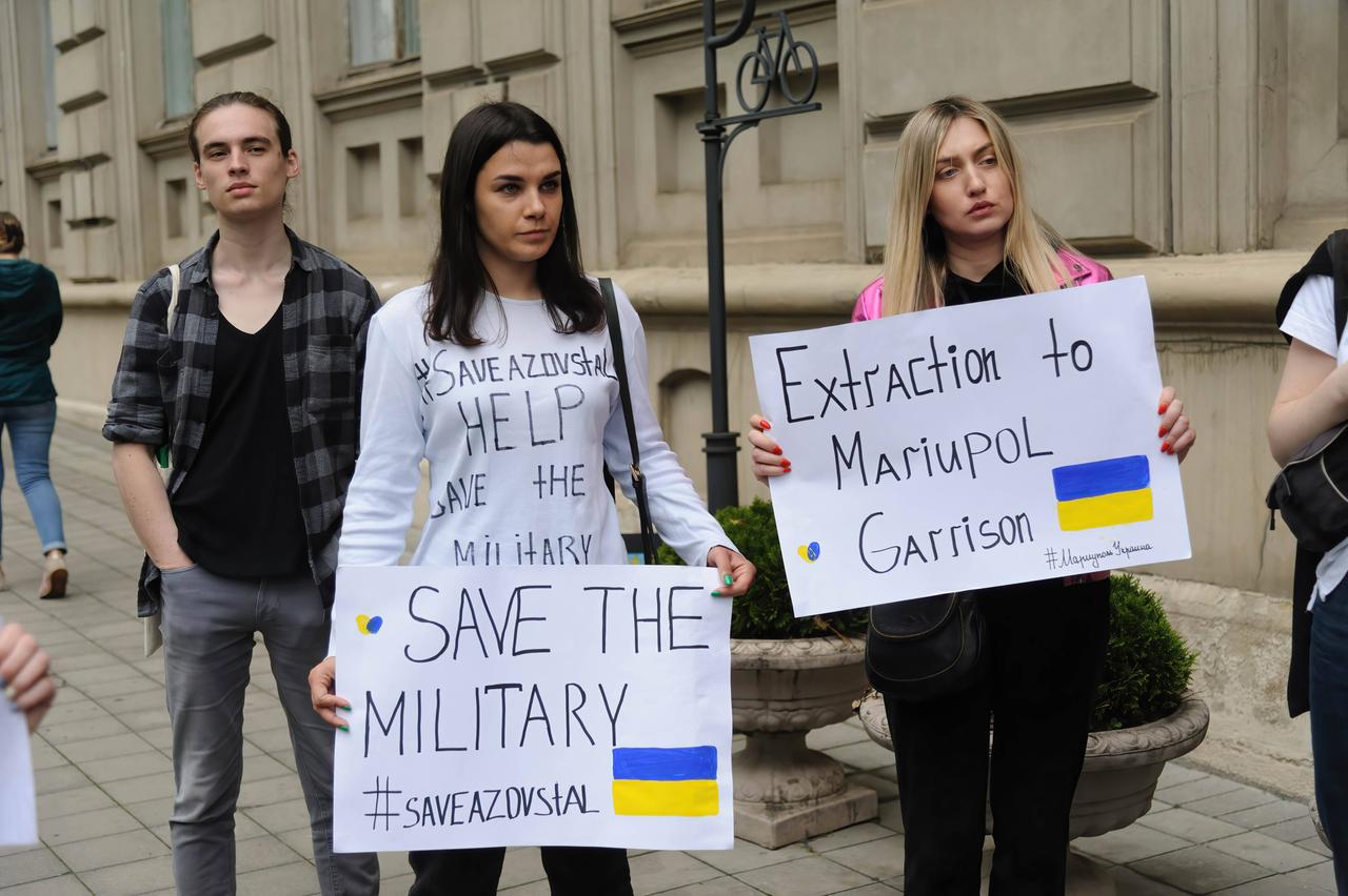 Demonstrierende in Lviv halten Plakate hoch. Darauf steht auf Englisch: "Schützt das Militär" und "Evakuierung aus Mariupol"