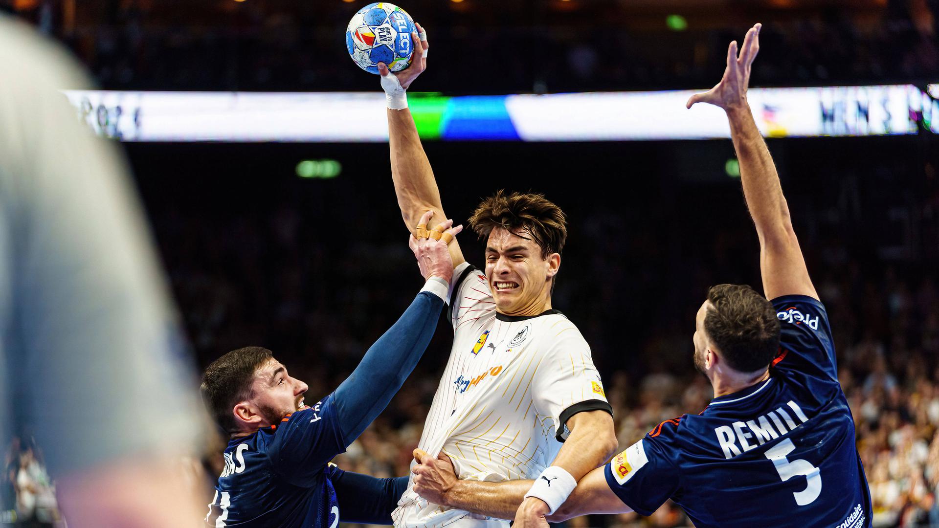 Handball-Europameisterschaft, Deutschland gegen Frankreich: Der deutsche Spieler Julian Koester hält den Ball in der Hand. Die französischen Spieler Ludovic Fabregas und Nedim Remili greifen ihn an.