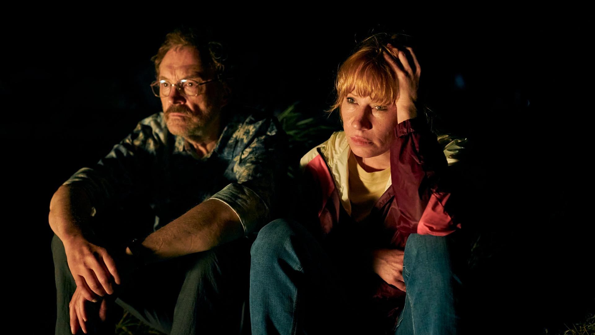 Josef Hader und Birgit Minichmayr sitzen in einer Szene  des Films  "Andrea lässt sich scheiden" in der Dunkelheit nebeneinander..