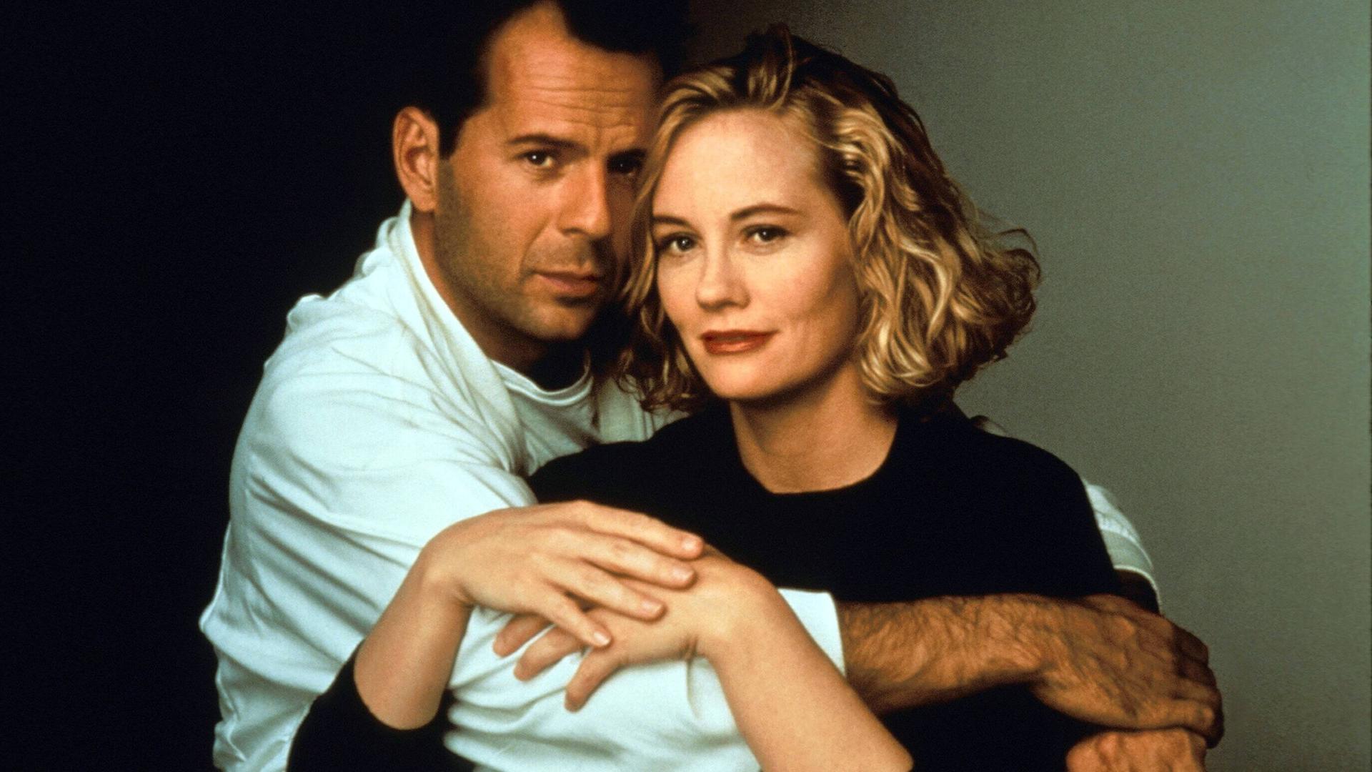 Bruce Willis hält Cybill Shepherd liebevoll umschlungen, sie legt ihre Hände auf seinen Arm.
