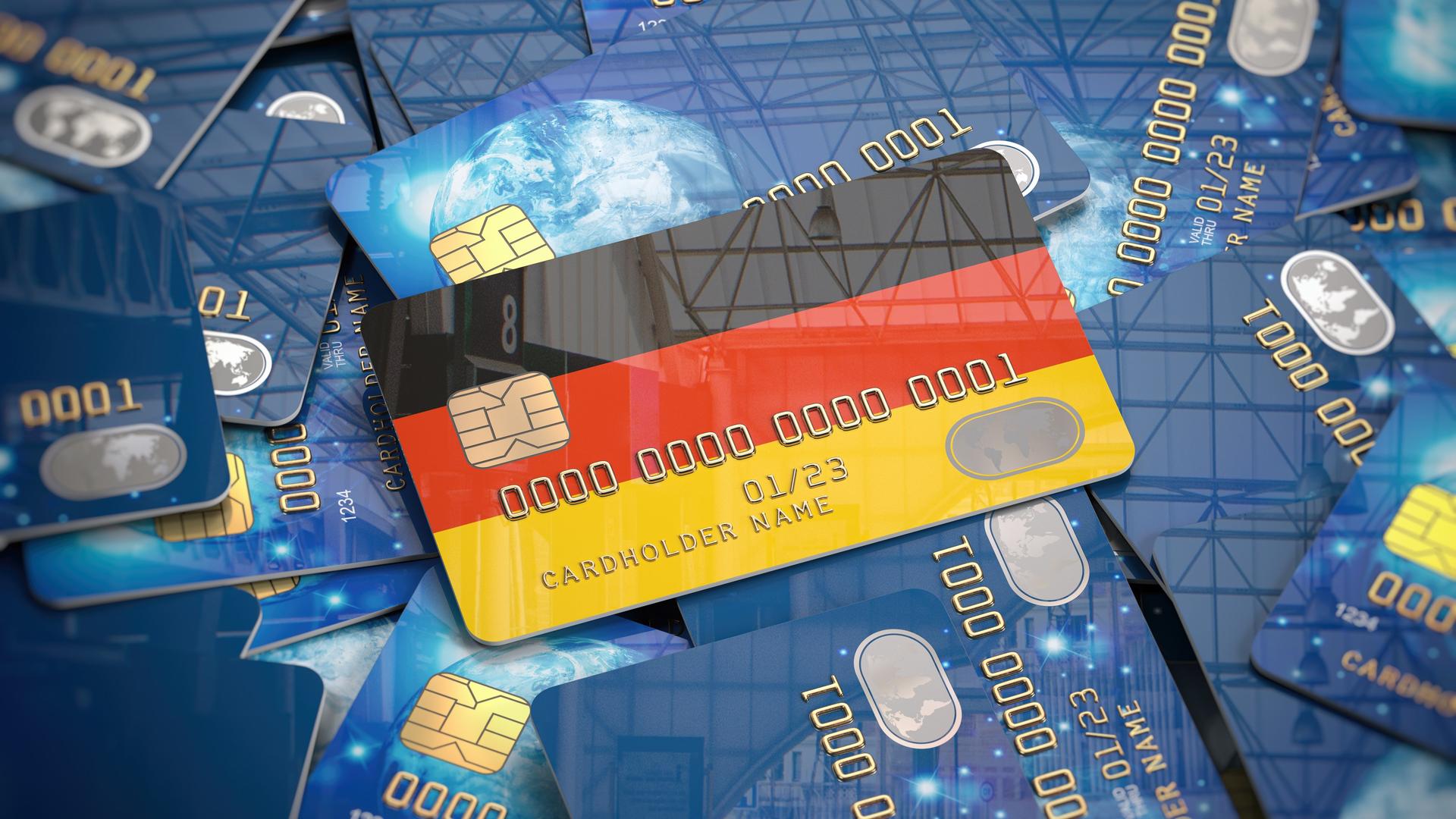 Illustration einer Kreditkarte mit den deutschen Nationalfarben, die auf einem Haufen anderer Kreditkarten liegt.