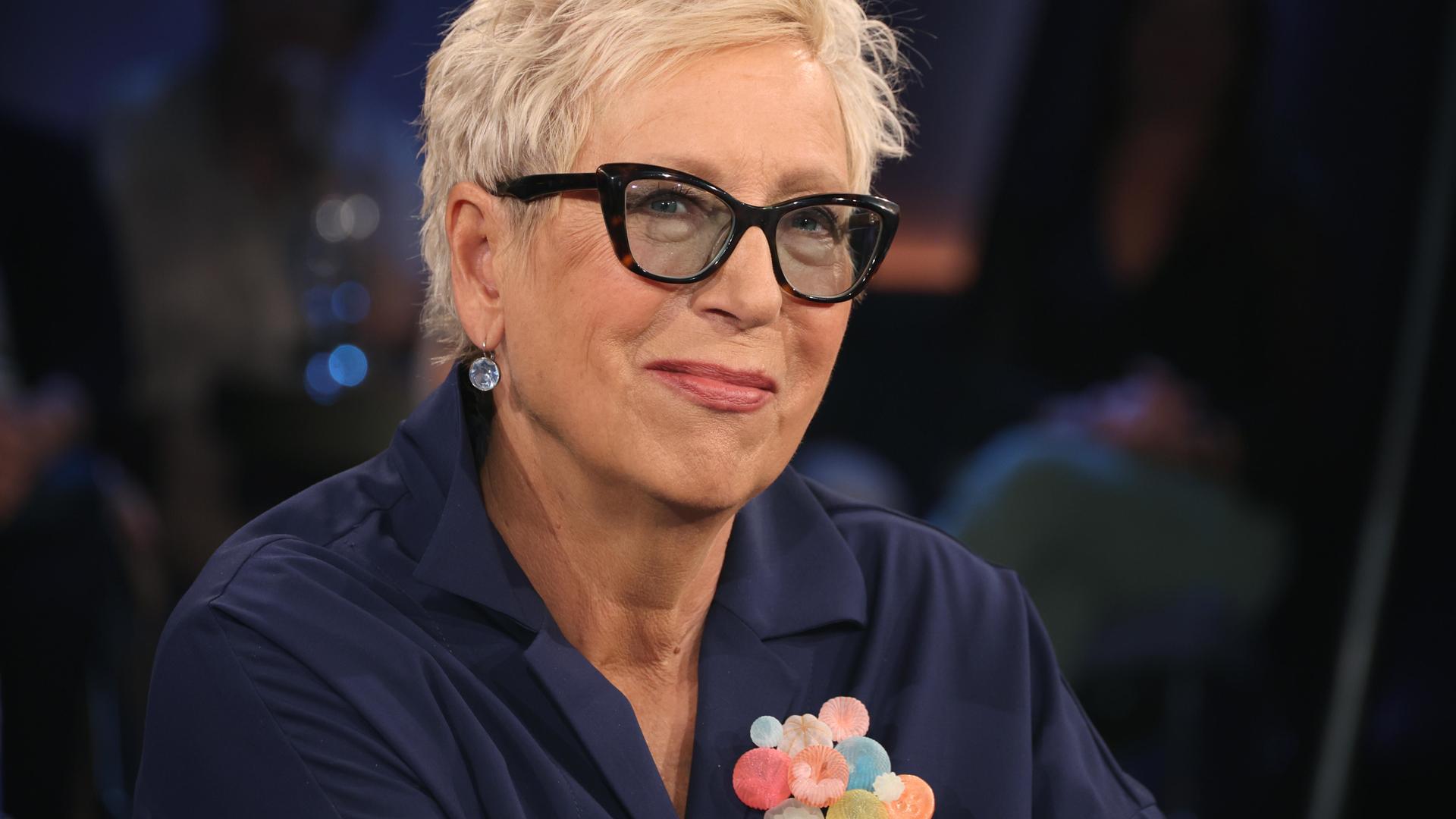 Eine Frau mit kurzen Haaren und Brille in einem Fernsehstudio Eine Frau mit kurzen Haaren und Brille in einem Fernsehstudio