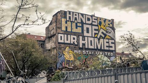 "Hands off our homes" steht auf einem Graffiti über der Wagenburg Köpi in der Köpenicker Straße in Berlin nach der Räumung durch die Polizei am 15.10.2021.