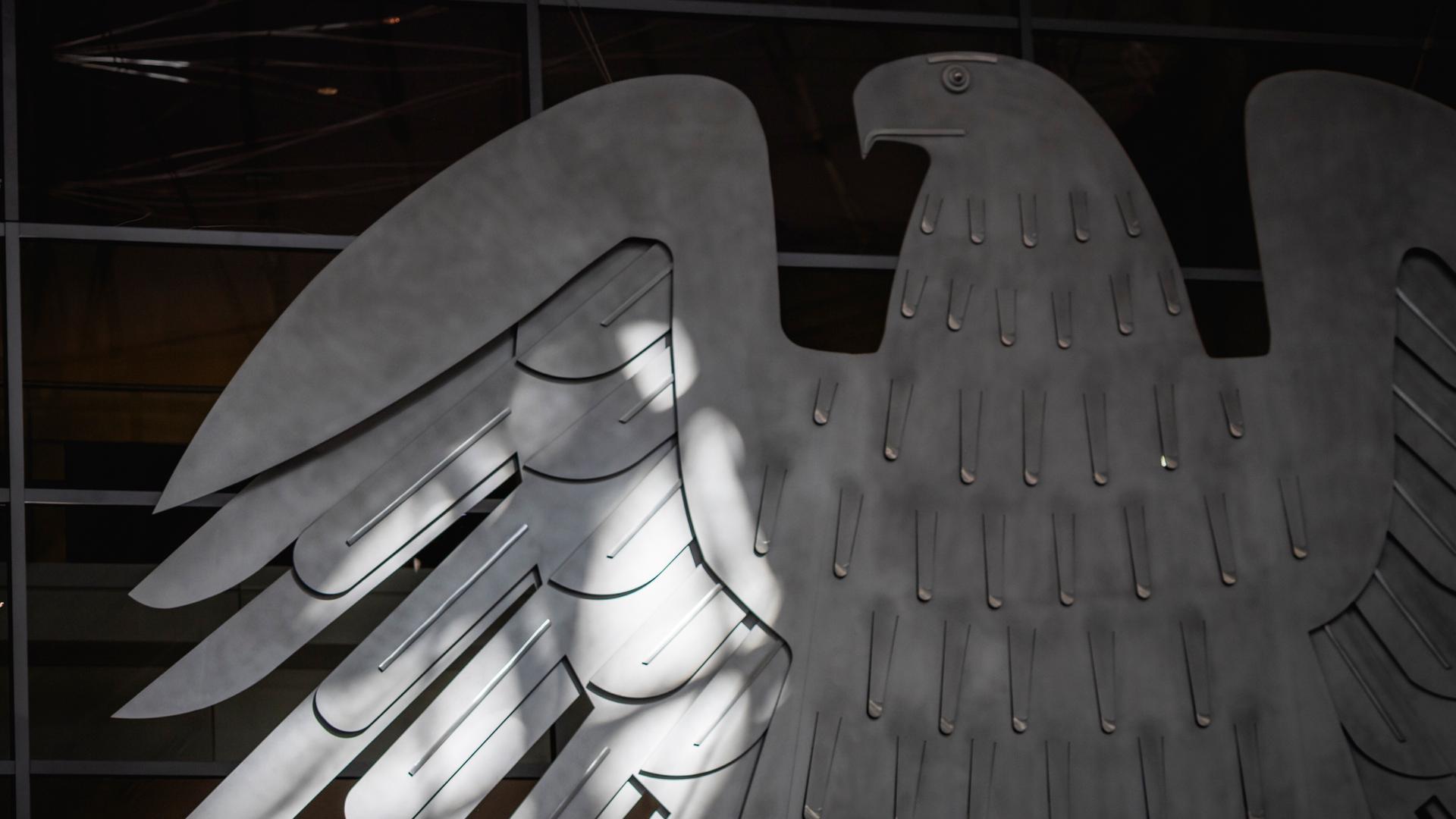 Der Bundesadler im Plenarsaal des Bundestags wird von der Sonne beschienen in Berlin. Der Bundesadler im Plenarsaal des Bundestags wird von der Sonne beschienen in Berlin.