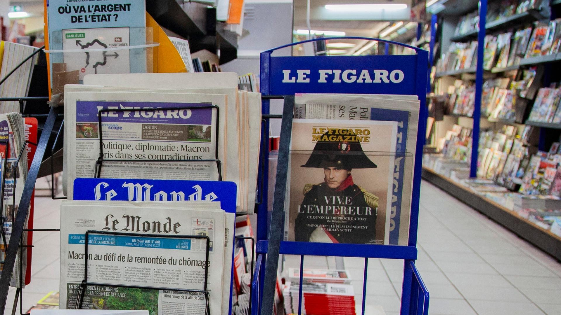 Die Zeitungen Le Monde und Le Figaro auf einem Zeitungsständer in einem Kiosk in Frankreich.