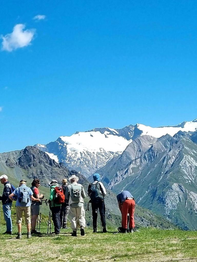 Eine Gruppe Wandertouristen steht vor dem Massiv des Großglockners im Nationalpark Hohe Tauern.