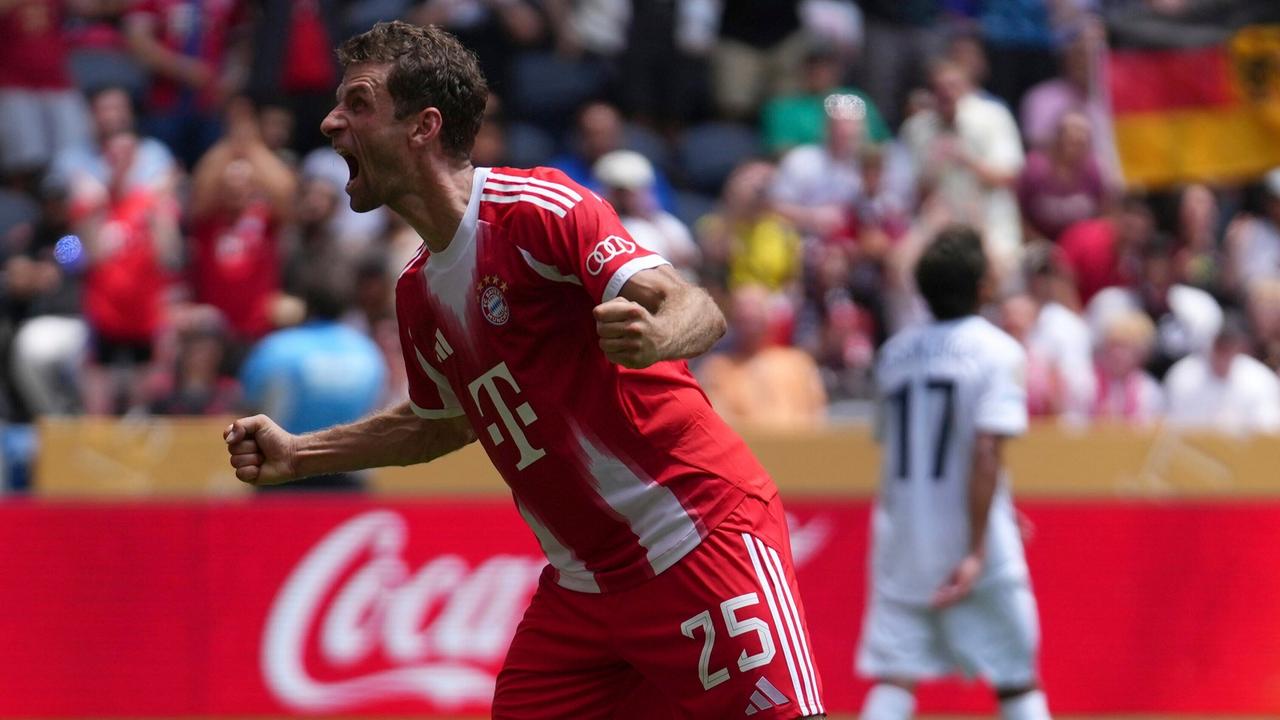 Müller im roten Trikot ballt jubelnd beide Fäuste und läuft über das Spielfeld. Man sieht ihn von der Seite.