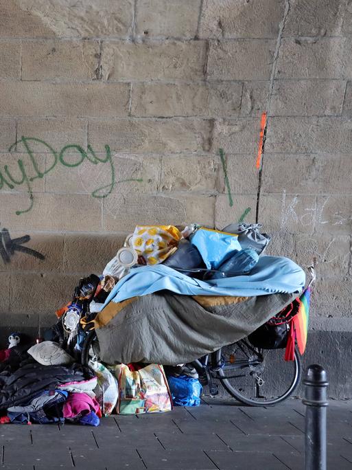 Die Habseligkeiten eines Obdachlosen stehen und liegen in einem Tunnel.