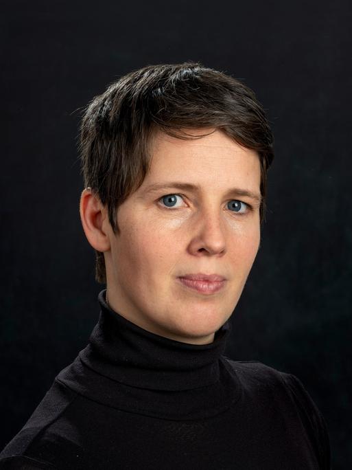 Porträt der Physikerin Viola Priesemann vor dunklem Hintergrund