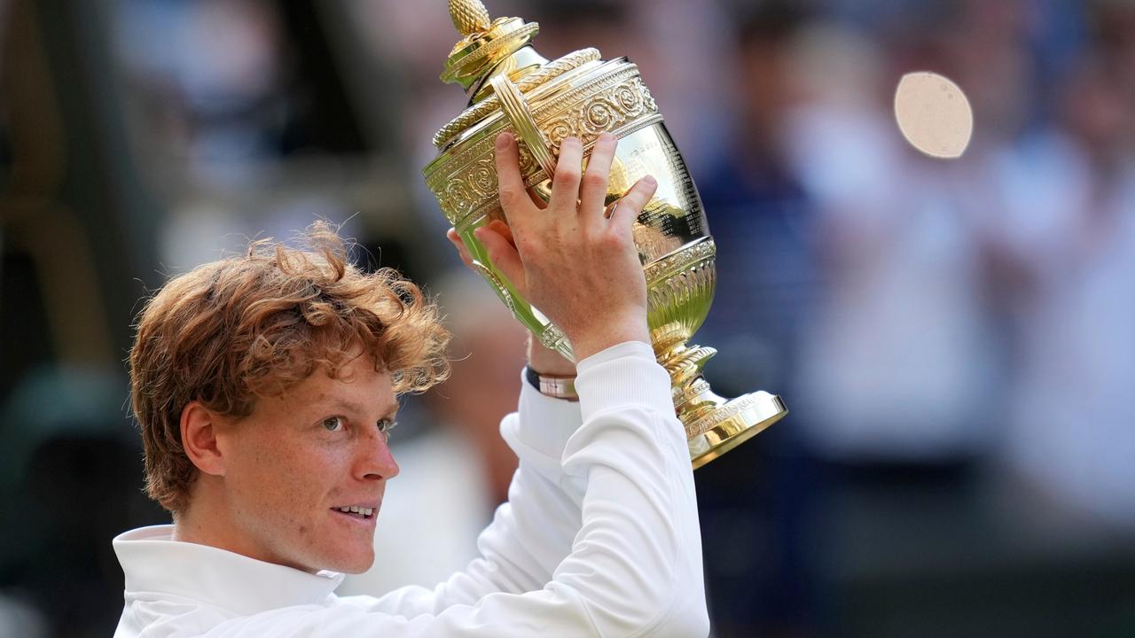 Das Bild zeigt den italienischen Tennisprofi Jannik Sinner, der den Siegerpokal in die Luft reckt.