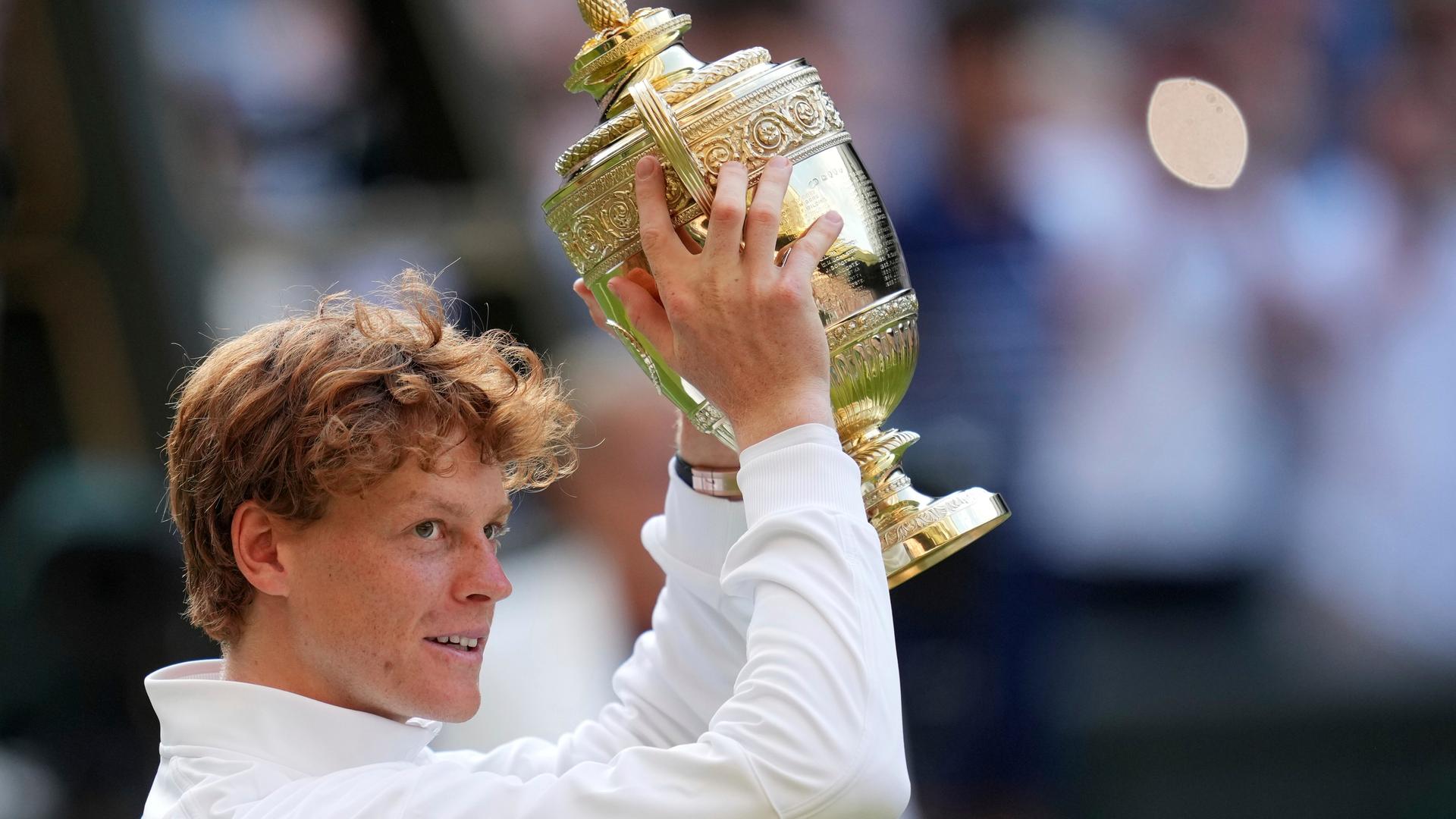 Das Bild zeigt den italienischen Tennisprofi Jannik Sinner, der den Siegerpokal in die Luft reckt. Das Bild zeigt den italienischen Tennisprofi Jannik Sinner, der den Siegerpokal in die Luft reckt.