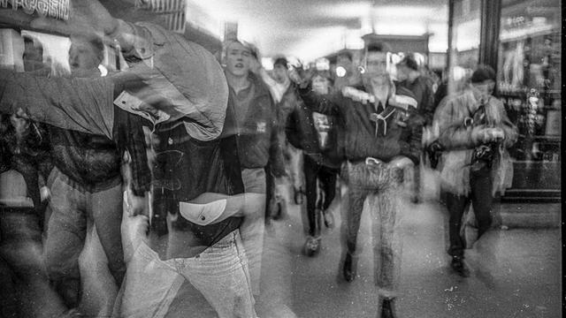 Eine bedrohliche Gruppe junger Männer in Bewegung und unscharf fotografiert.