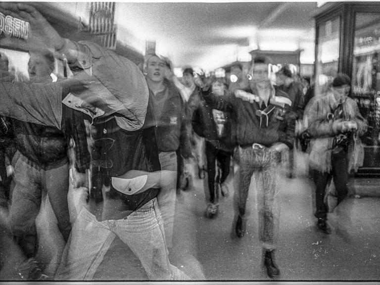 Eine bedrohliche Gruppe junger Männer in Bewegung und unscharf fotografiert.