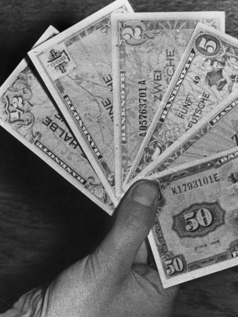 Eine Hand hält sechs Deutsche-Mark-Banknoten