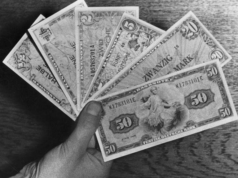 Eine Hand hält sechs Deutsche-Mark-Banknoten