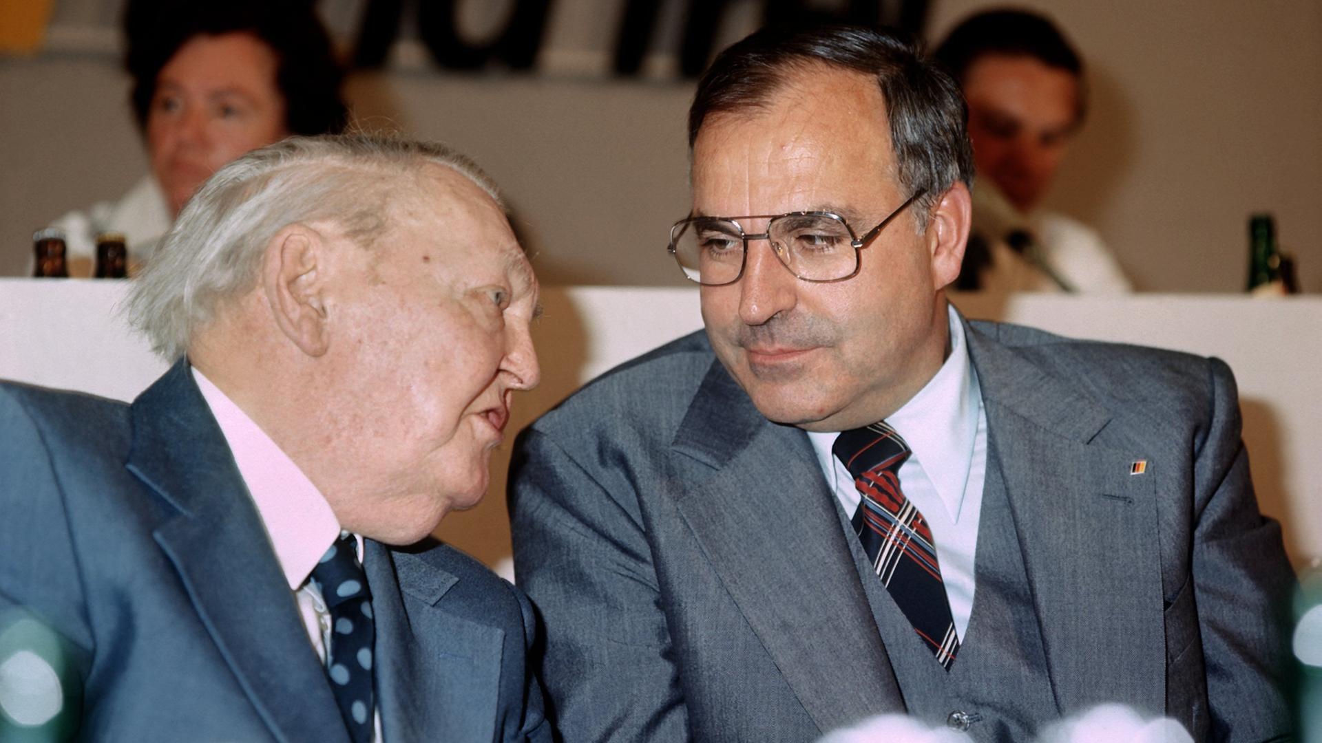 Ludwig Erhard und Helmut Kohl sprechen auf dem CDU Parteitag 1976 in Hannover miteinander.