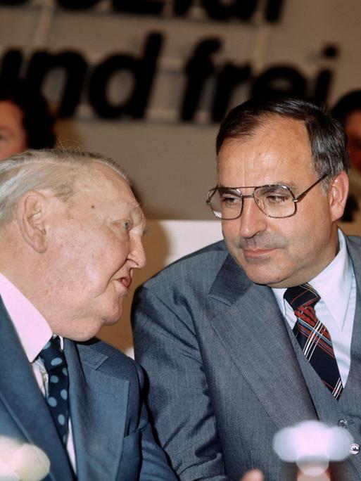 Ludwig Erhard und Helmut Kohl sprechen auf dem CDU Parteitag 1976 in Hannover miteinander.