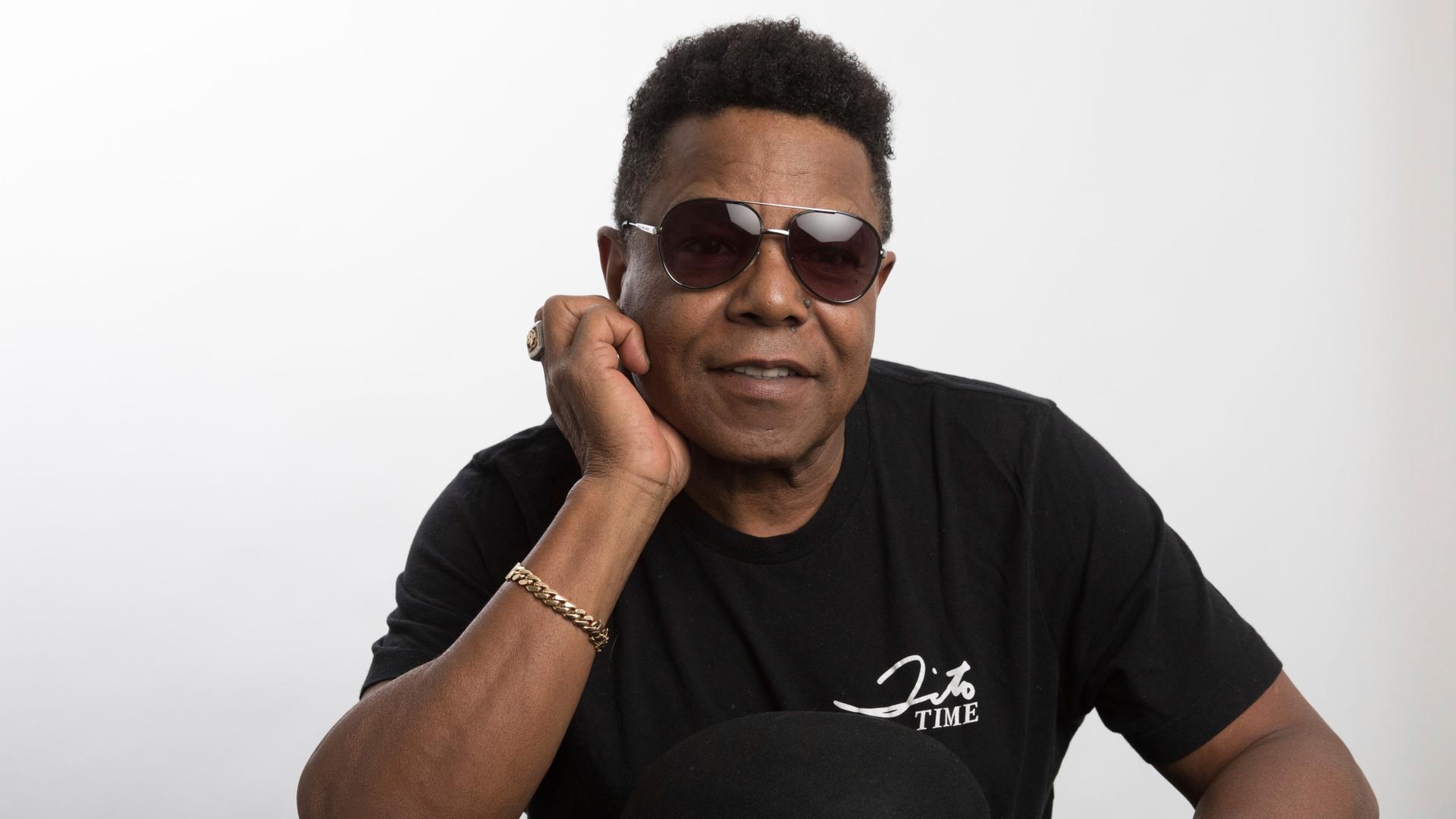 Tito Jackson, Mitglied der Jackson 5, schaut lächelnd mit Sonnenbrille in die Kamera im Jahr 2019.