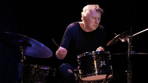 Ein Mann spielt mit geschlossenen Augen Schlagwerk.