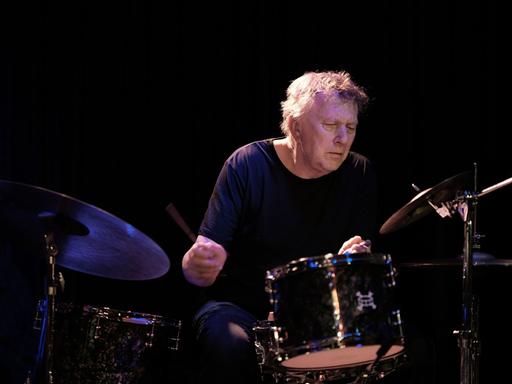 Ein Mann spielt mit geschlossenen Augen Schlagwerk.