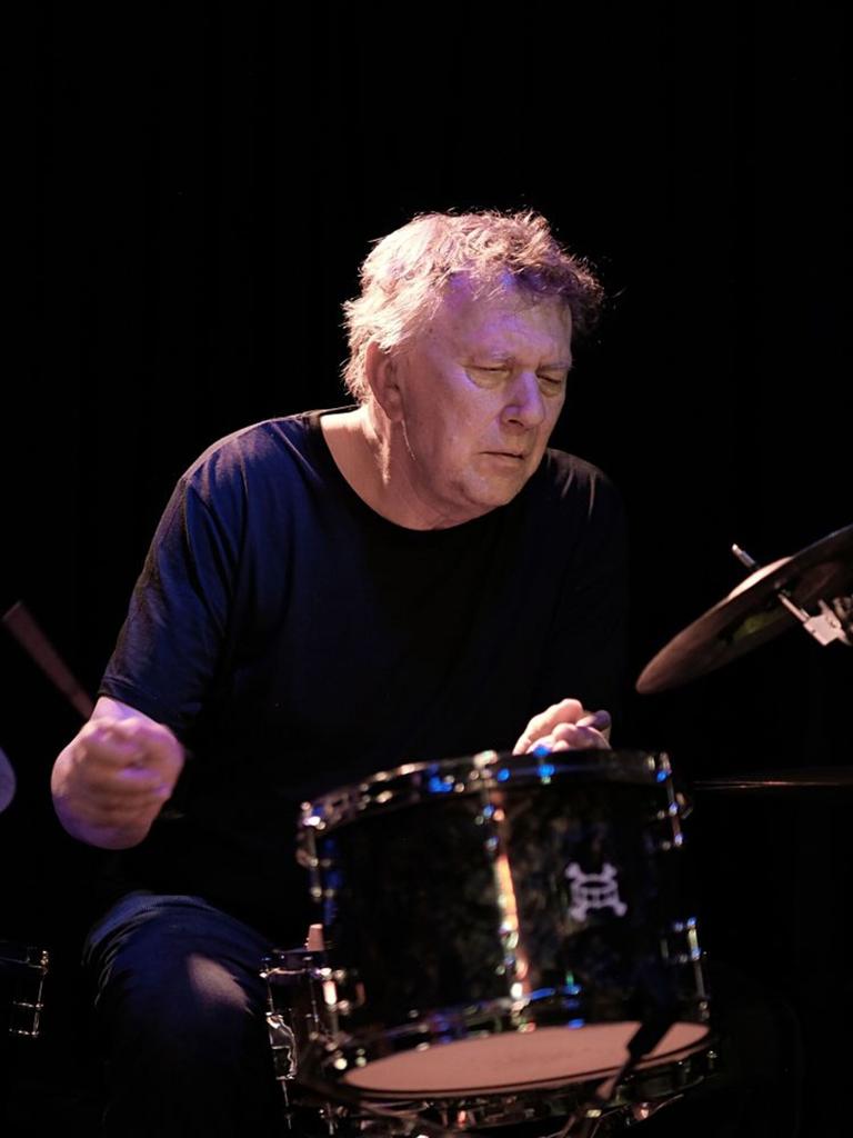 Ein Mann spielt mit geschlossenen Augen Schlagwerk.