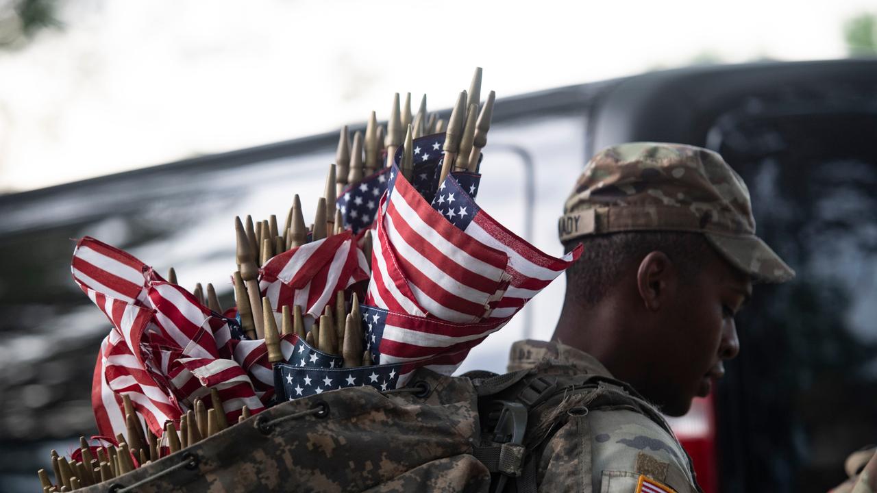 Memorial Day in Arlington: Ein US-Soldat trägt Flaggen in einem Rucksack. Mit diesen sollen gefallene Soldaten geehrt werden.