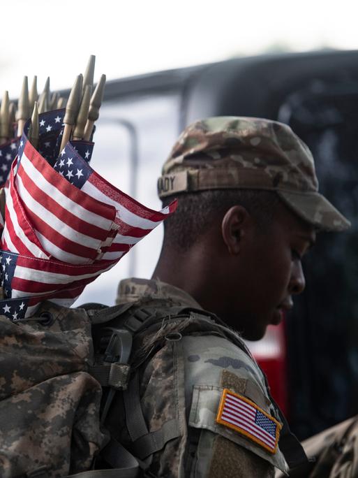 Memorial Day in Arlington: Ein US-Soldat trägt Flaggen in einem Rucksack. Mit diesen sollen gefallene Soldaten geehrt werden.