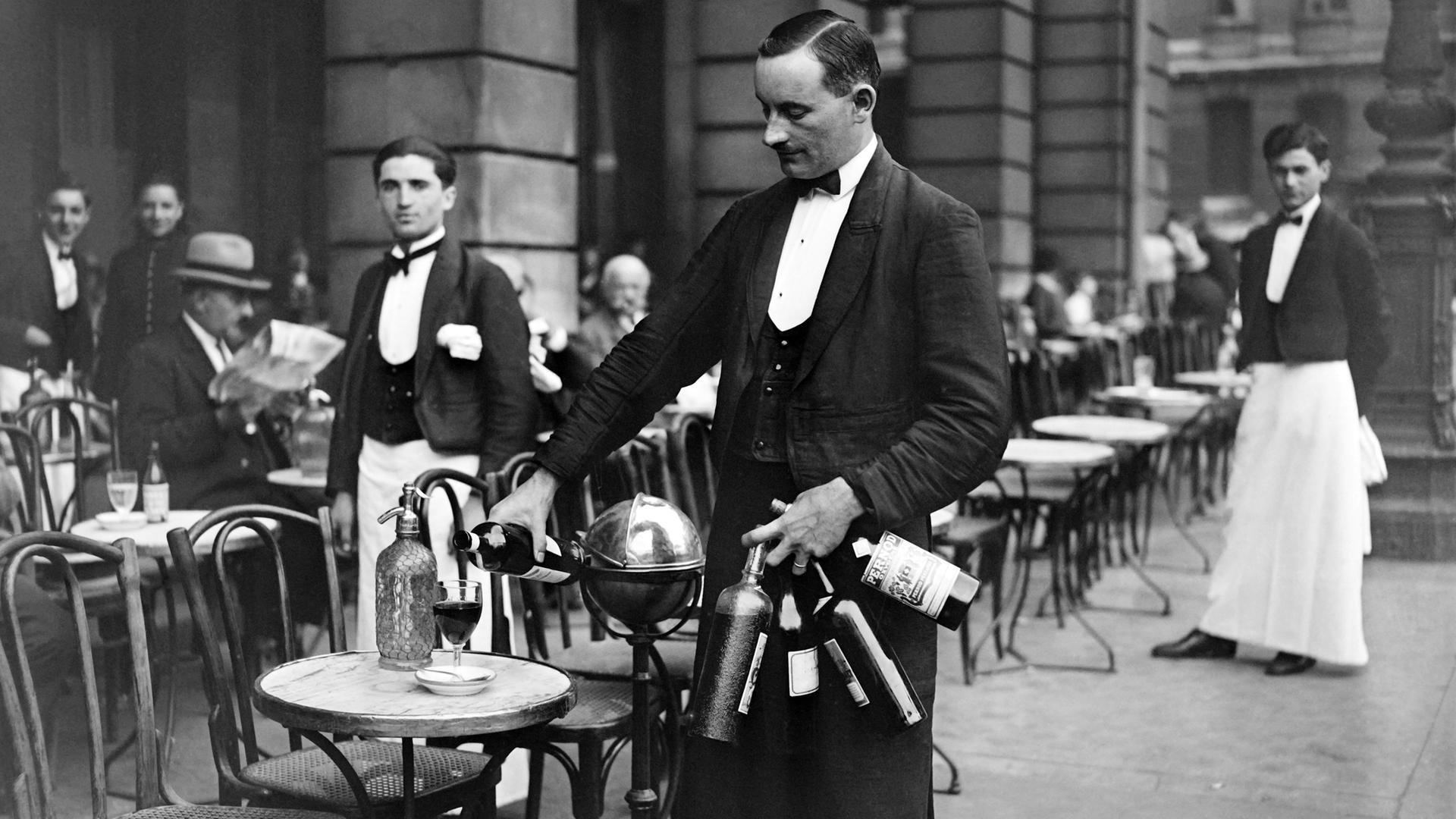 Ein Kellner, der im Jahr 1928 in einem Pariser Bistro Wein einschenkt.